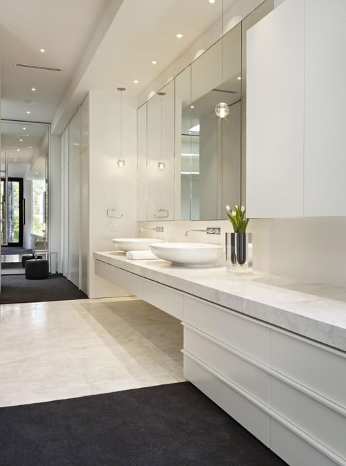 В ванной комнате с высокими потолками будет уместно разместить точечное освещение над зеркалом и несколько подвесных светильников по бокам от него на уровне 120-150 см от пола